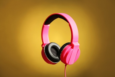 Photo of Stylish headphones with pads on color background