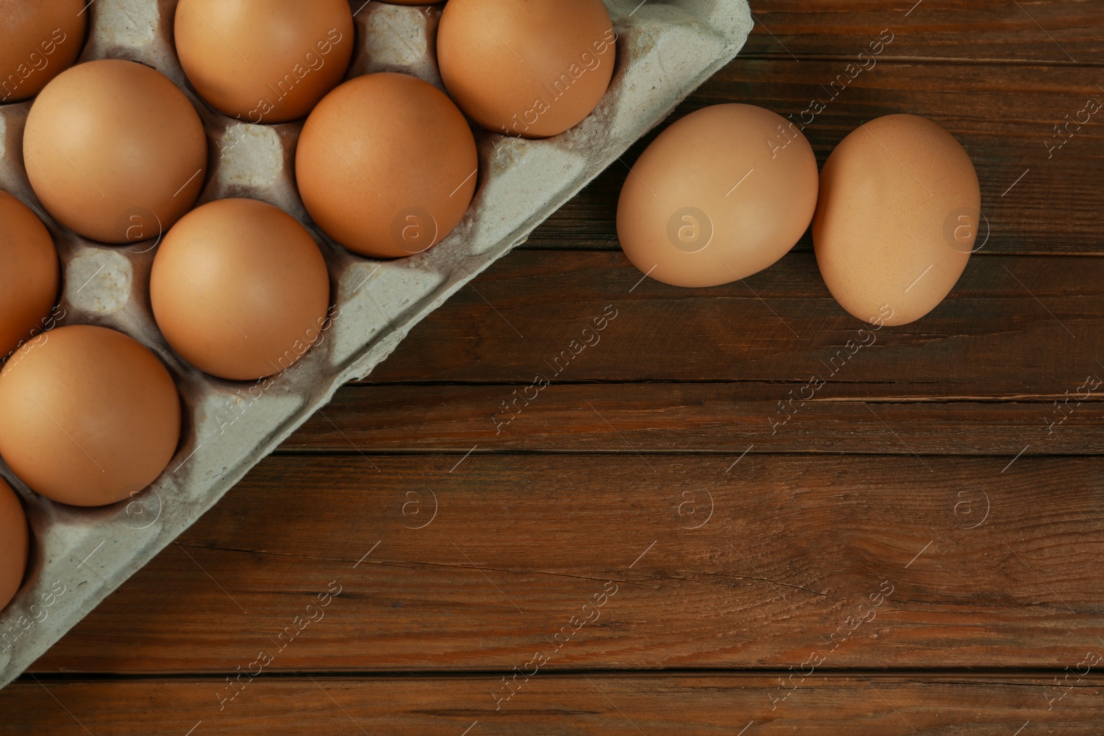 Photo of Raw chicken eggs on wooden table, flat lay