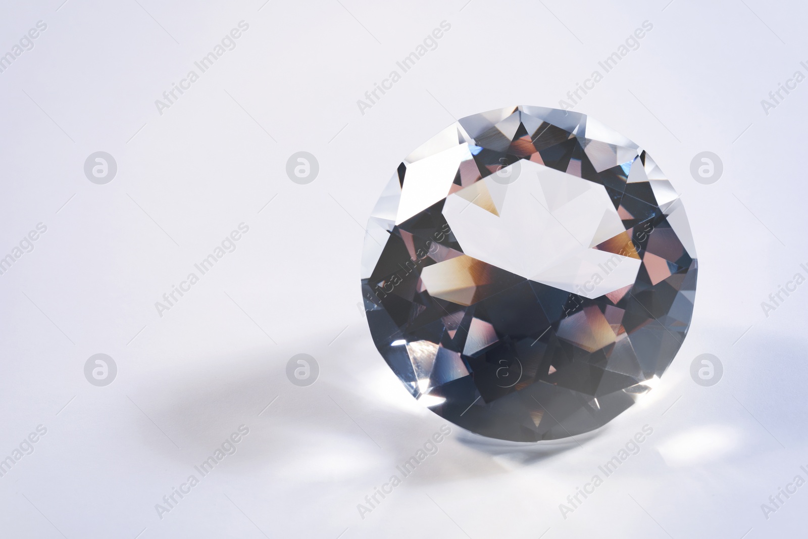 Photo of Beautiful dazzling diamond on white background, closeup. Space for text