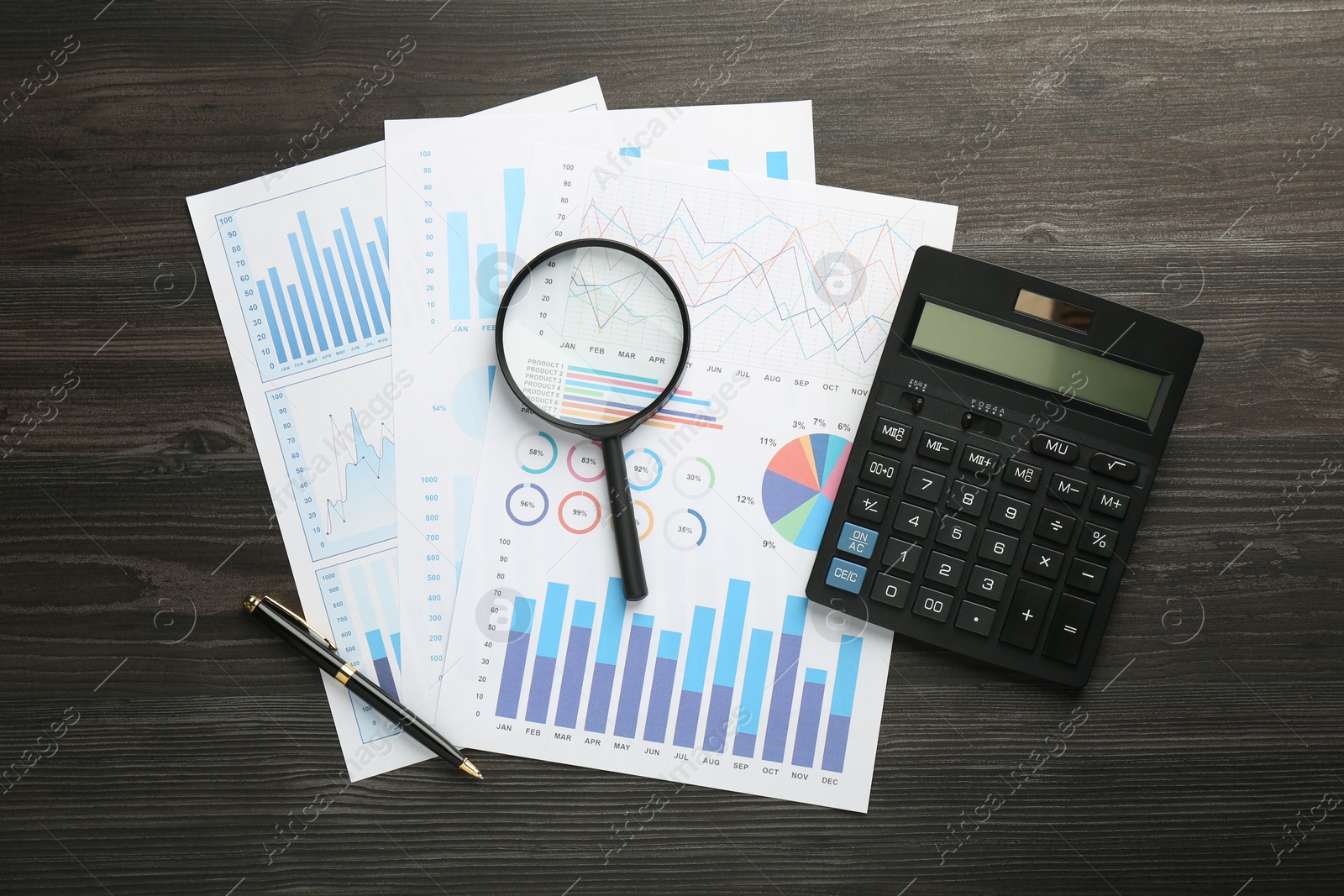 Photo of Accounting documents, magnifying glass, calculator and pen on wooden table, top view