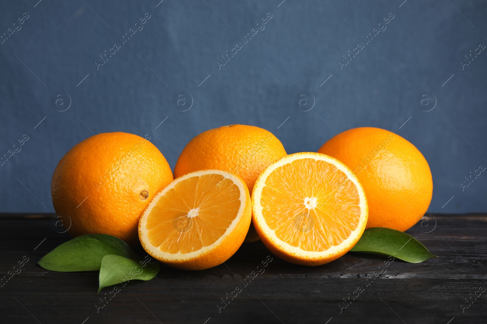 Photo of Fresh oranges with leaves on wooden table