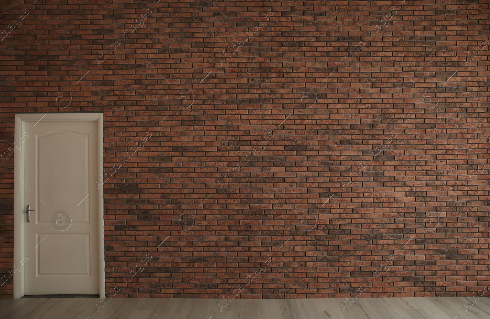 Photo of Empty room with brick wall and white door