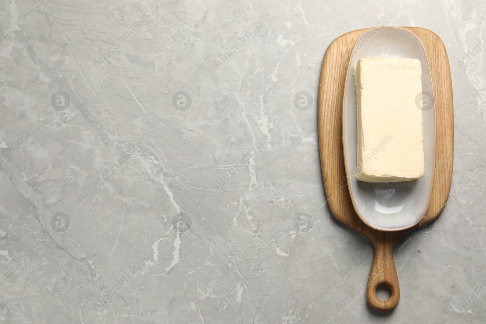 Photo of Block of tasty butter on grey table, top view. Space for text