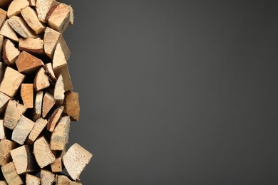 Cut firewood on grey background. Space for text