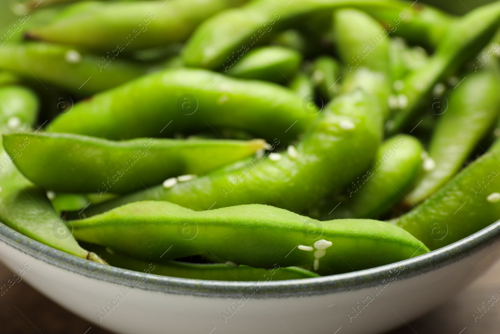 Photo of Bowl with green edamame beans in pods, closeup