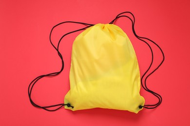 Photo of Yellow drawstring bag on red background, top view