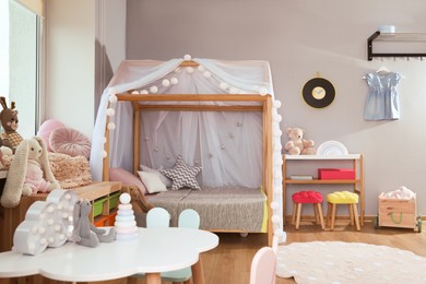 Photo of Stylish child room interior with comfortable house bed