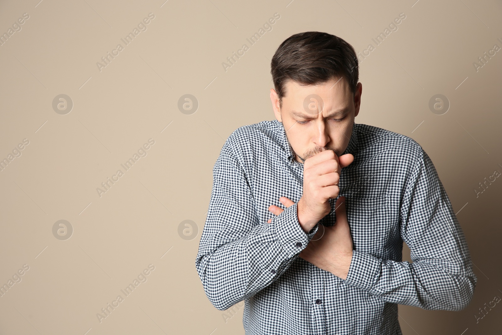 Photo of Man suffering from cough on color background. Space for text