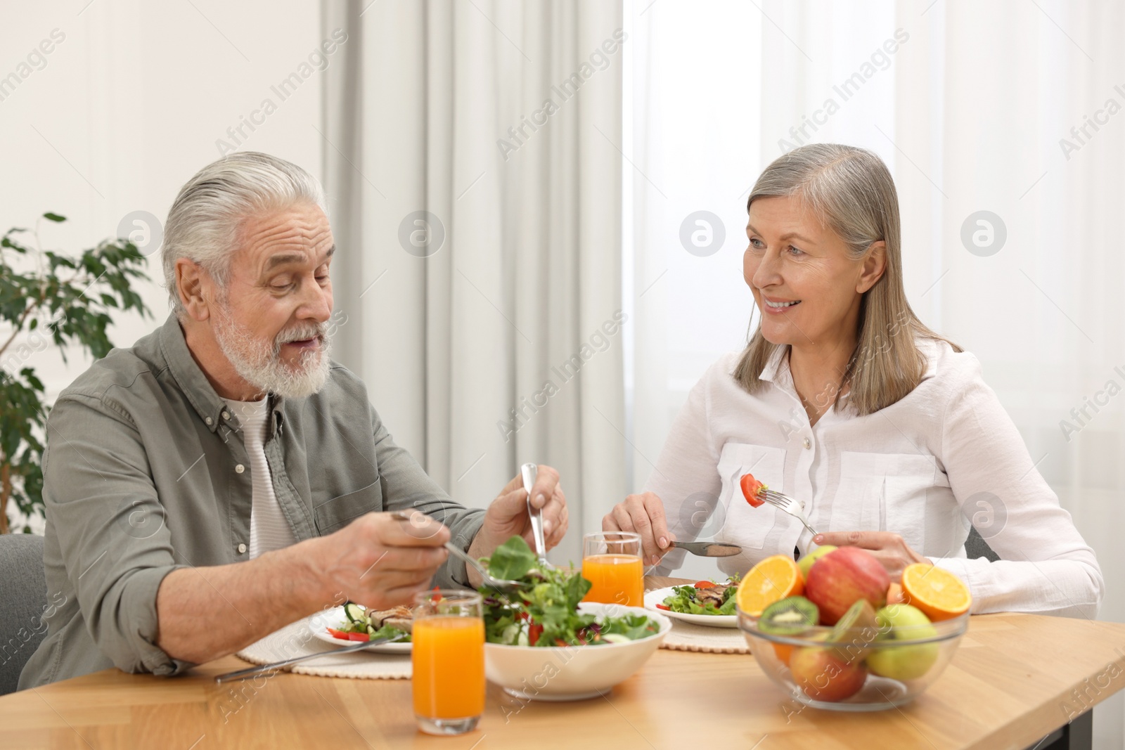 Photo of Happy senior couple having dinner at home