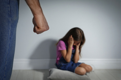 Man threatening his daughter indoors, closeup. Domestic violence concept