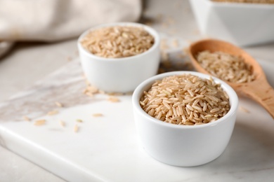 Uncooked brown rice in small bowl on table