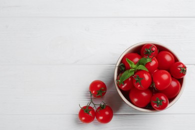 Photo of Fresh ripe cherry tomatoes and basil on white wooden table, flat lay. Space for text