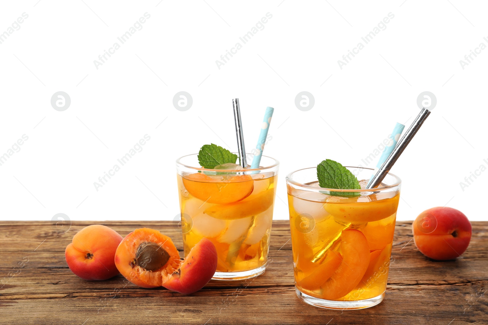 Photo of Delicious refreshing drink with apricot on wooden table against white background