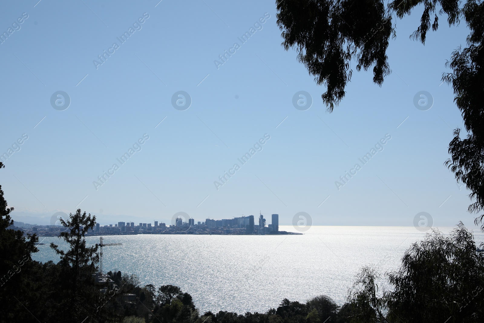 Photo of Picturesque view of beautiful sea and distant city under blue sky