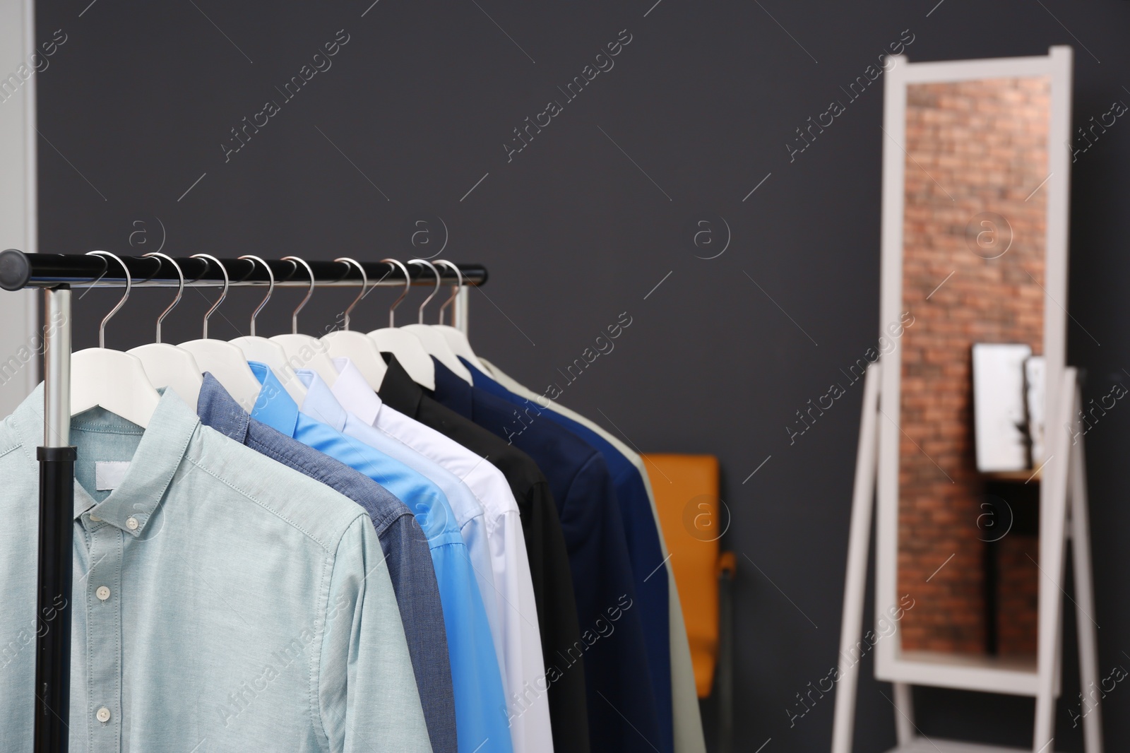 Photo of Wardrobe rack with stylish clothes in dressing room. Space for text