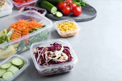 Set of plastic containers with fresh food on light table