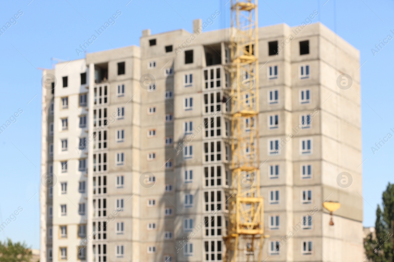 Photo of Blurred view of unfinished building and tower crane outdoors