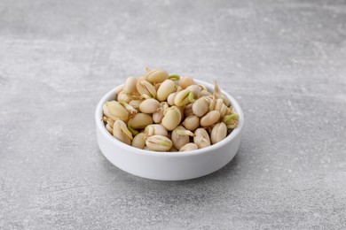 Photo of Sprouted kidney beans in bowl on light grey table, closeup
