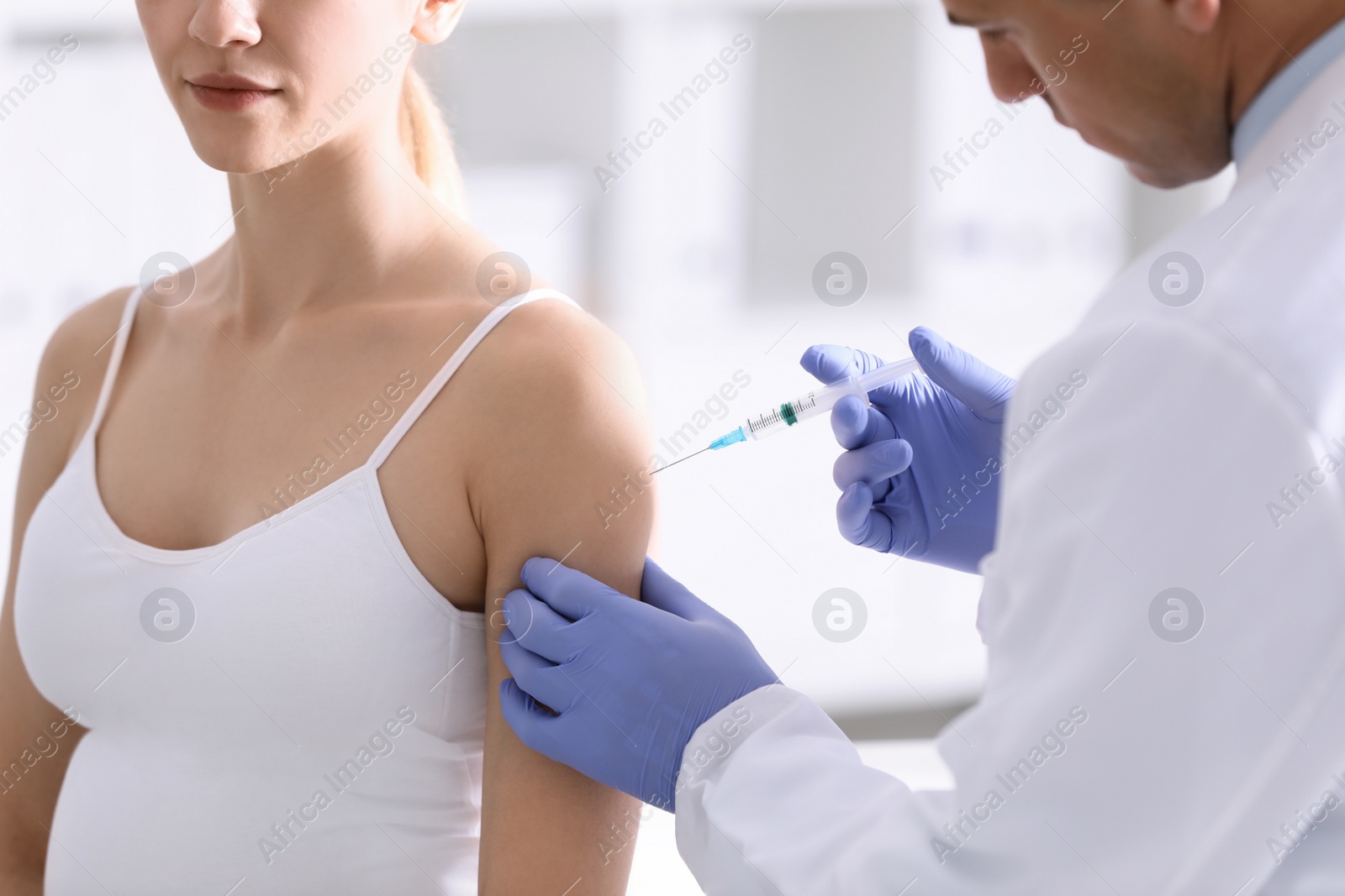 Photo of Doctor giving injection to pregnant woman in hospital, closeup. Vaccination concept