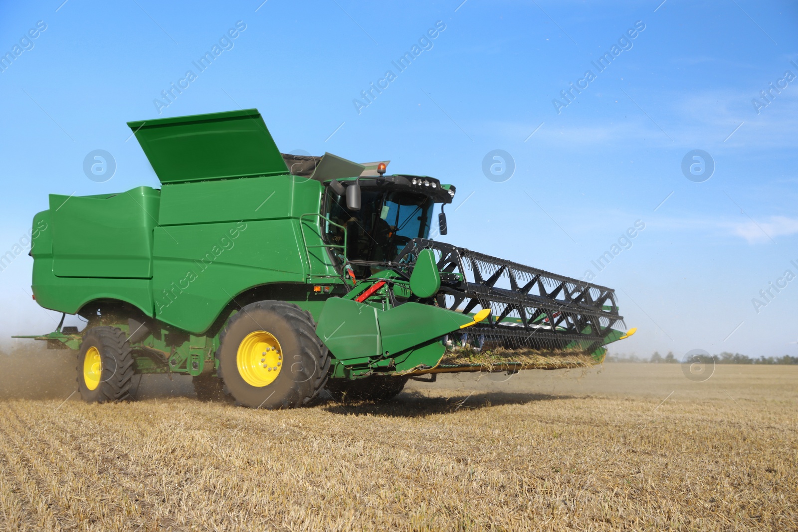 Photo of Modern combine harvester working in agricultural field