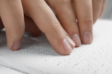 Photo of Blind person reading book written in Braille, closeup