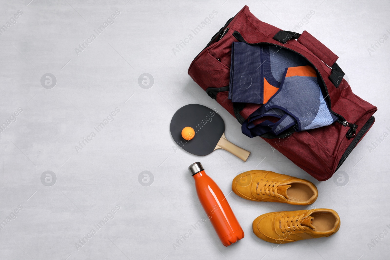 Photo of Sports bag and table tennis equipment on white  background, flat lay. Space for text