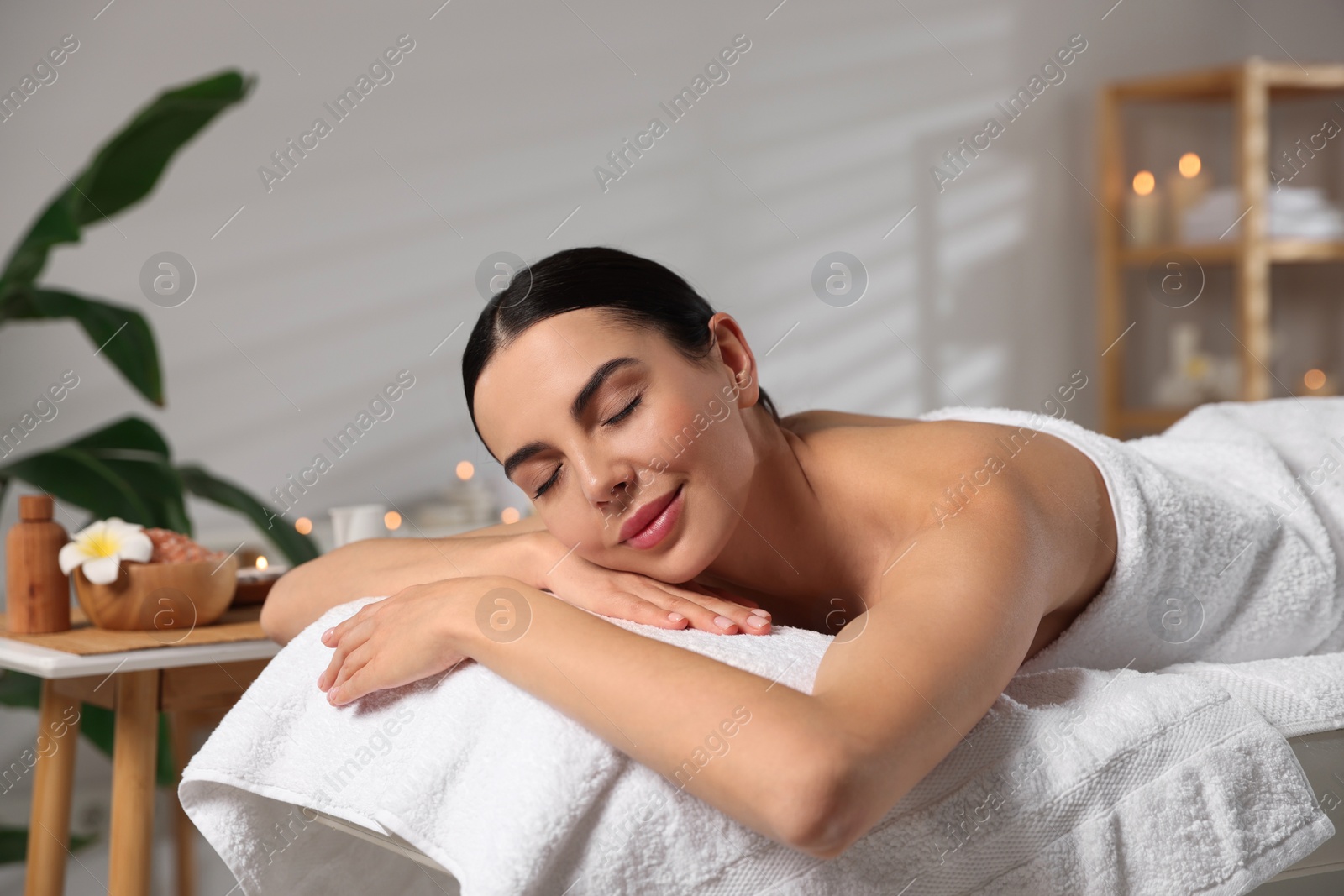 Photo of Beautiful woman relaxing on massage table in spa salon