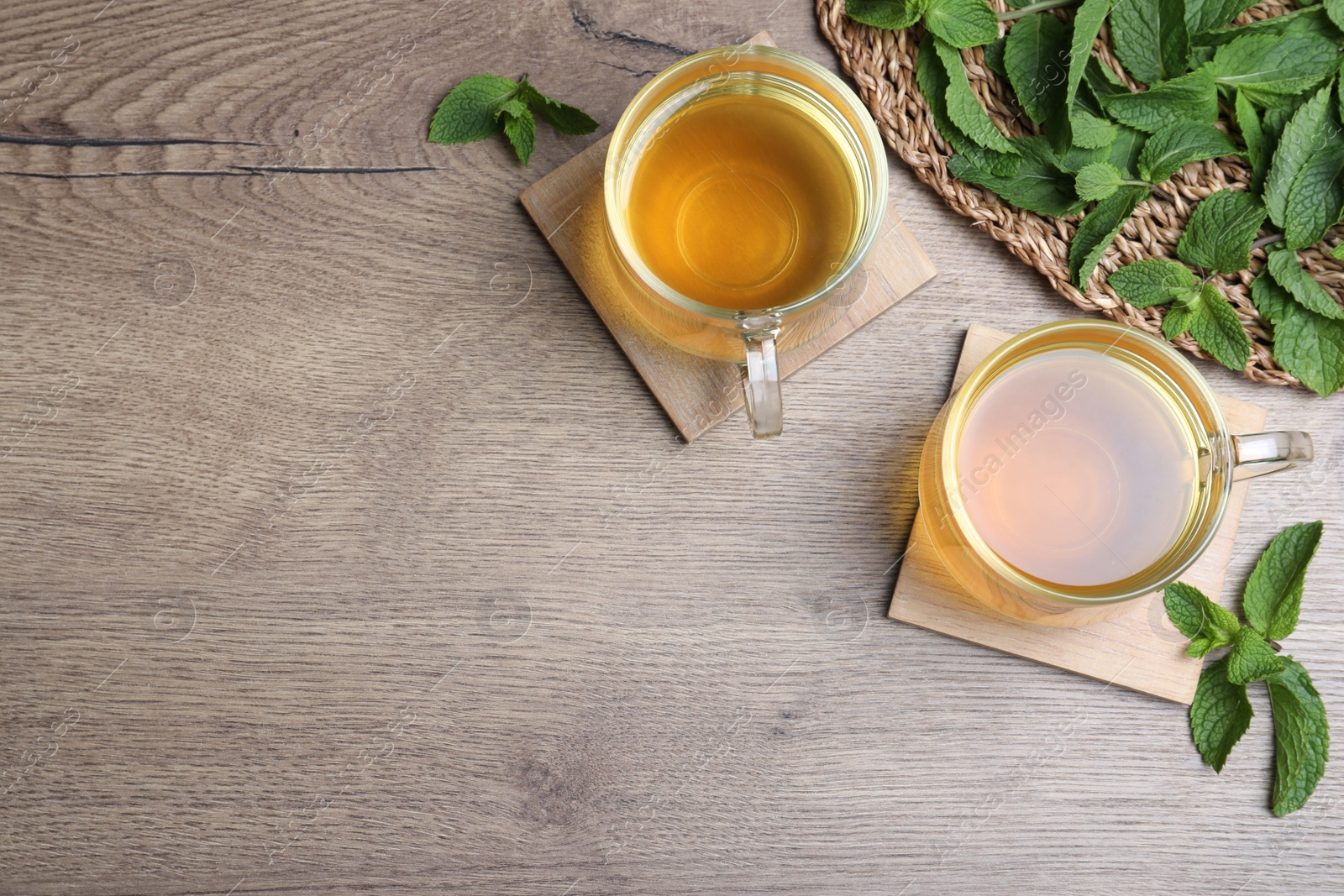 Photo of Fresh green tea with mint on wooden table, flat lay. Space for text