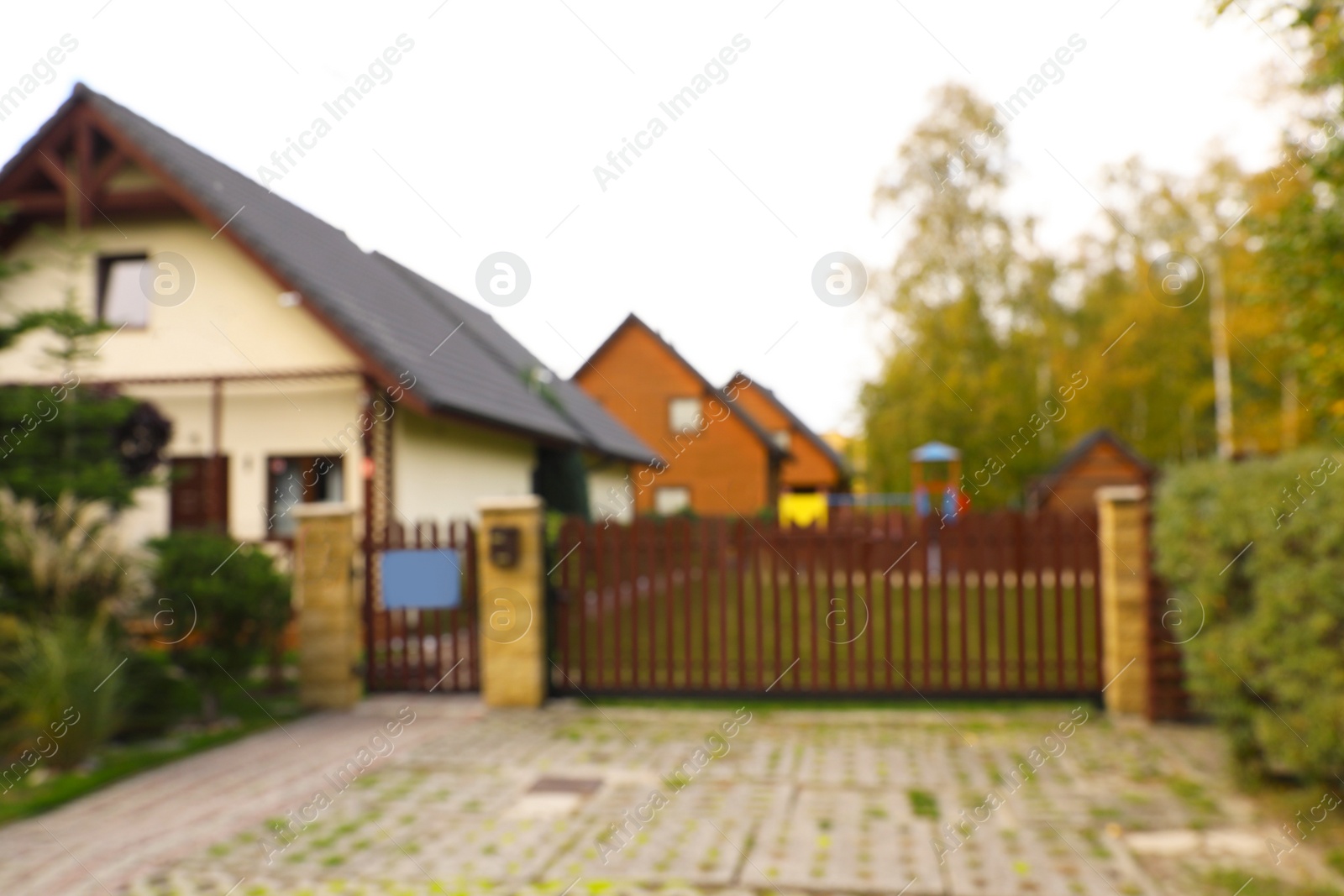 Photo of Beautiful cottage houses outdoors, blurred view. Real estate for rent