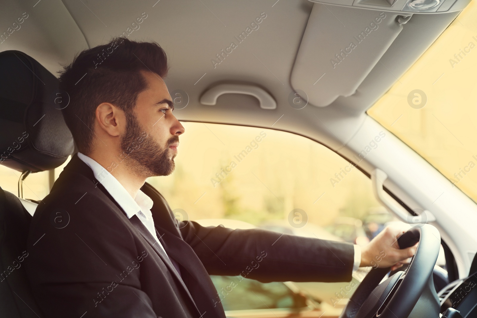 Image of Handsome young man driving his modern car