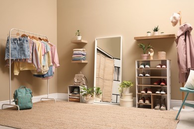 Stylish dressing room interior with trendy clothes and shoes