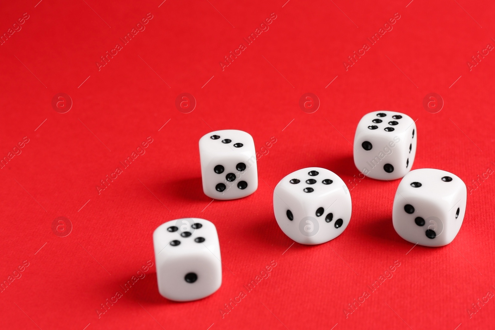 Photo of Many white game dices on red background