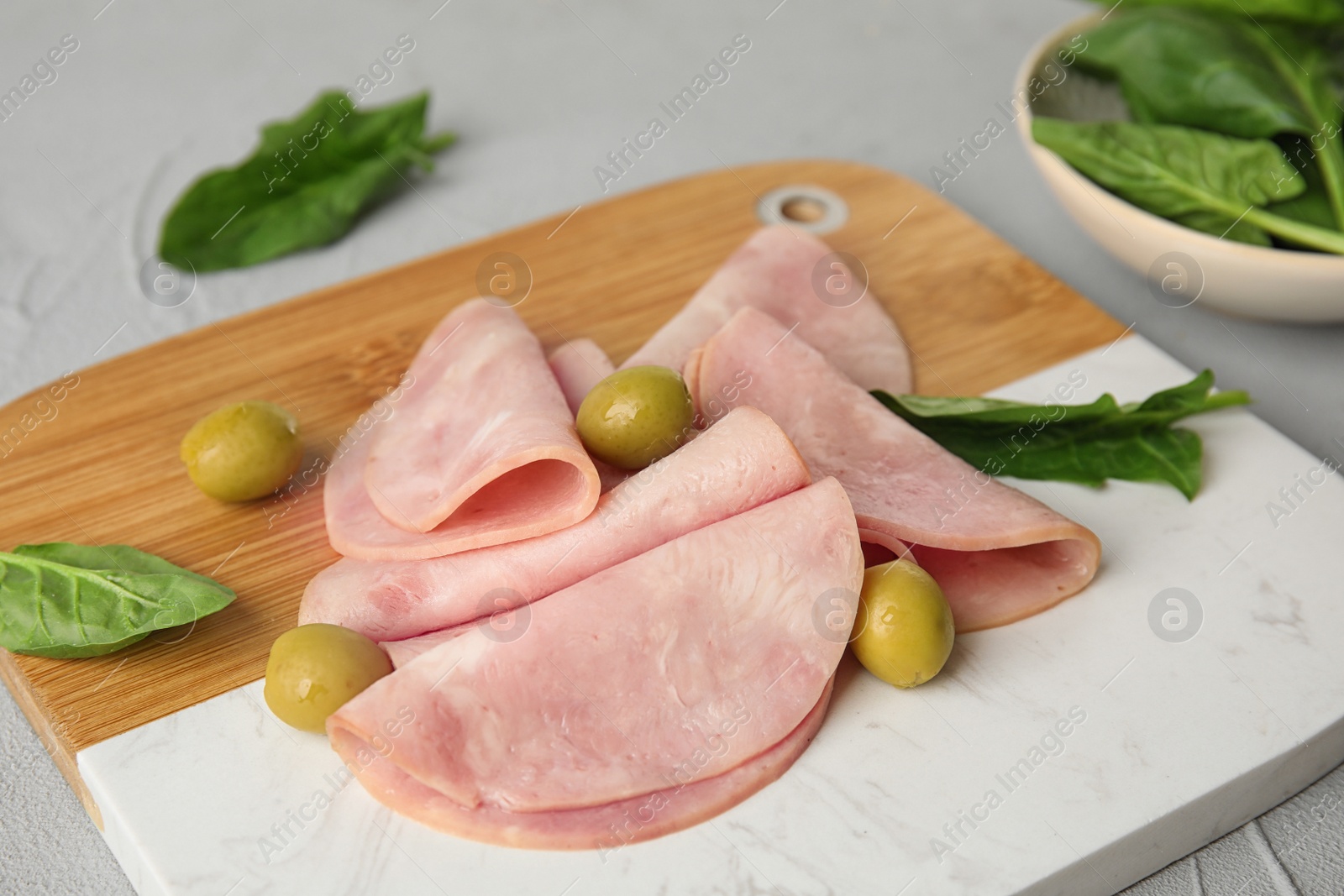 Photo of Ham with olives and spinach on table