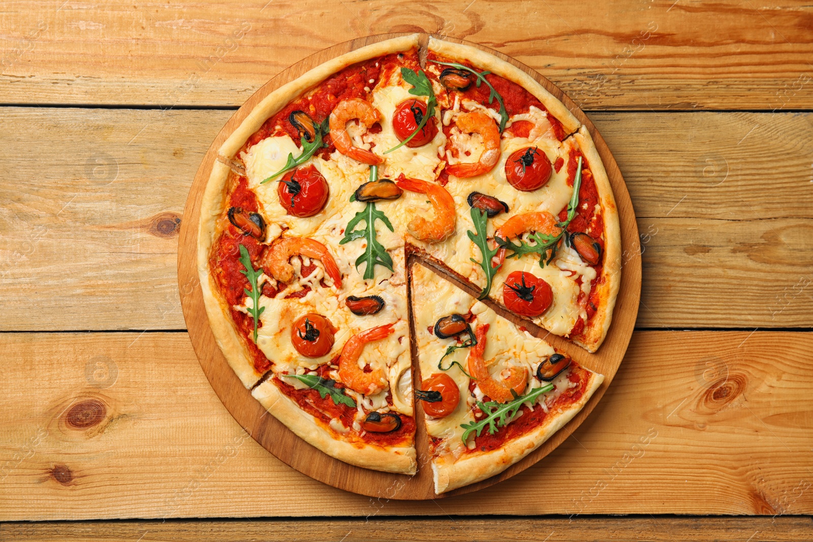 Photo of Delicious seafood pizza on wooden table, top view