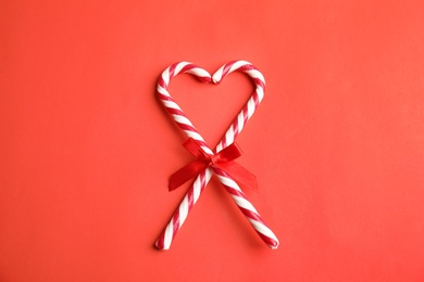 Photo of Candy canes on red background, flat lay