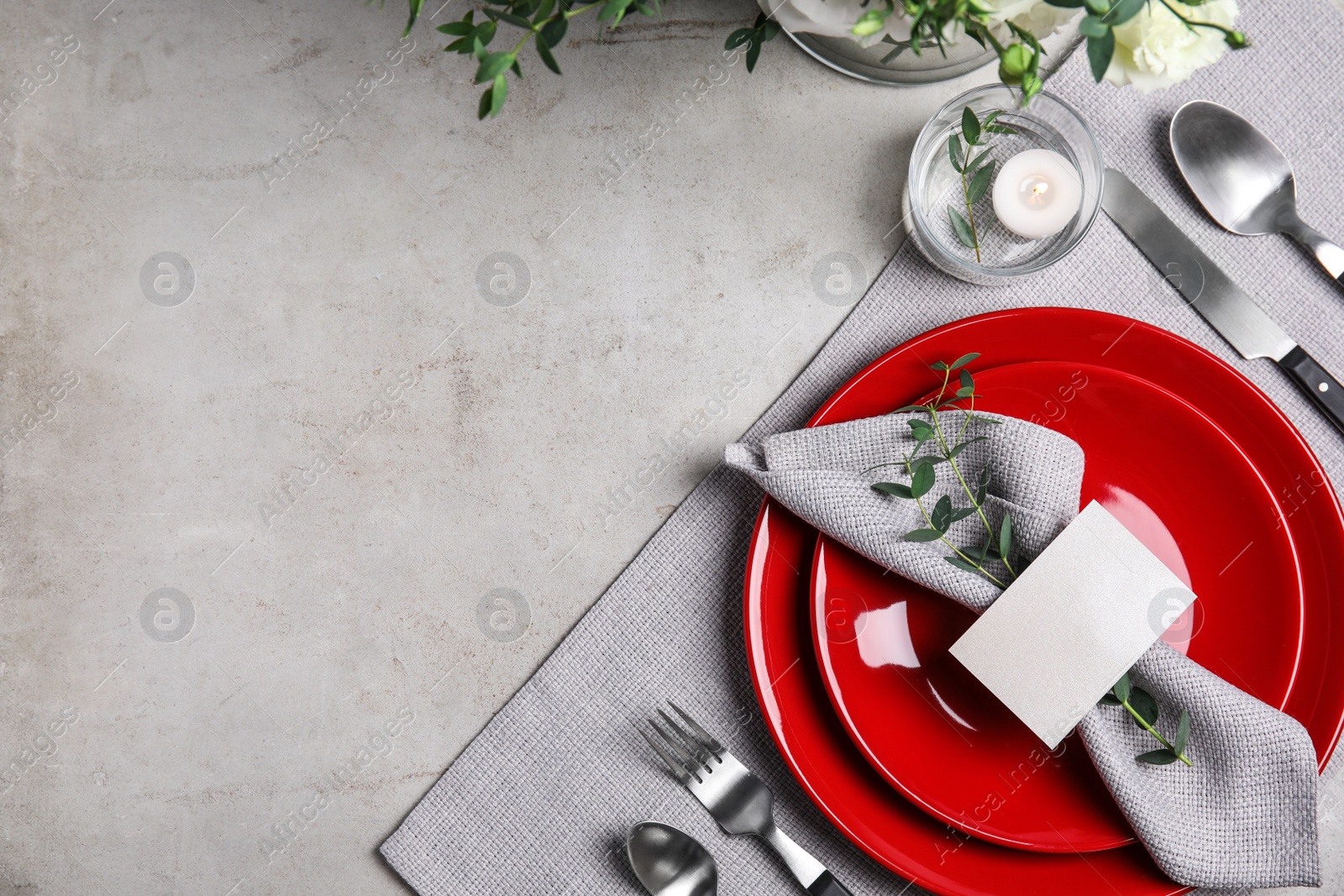 Photo of Elegant festive table setting with blank card on grey background, flat lay. Space for text