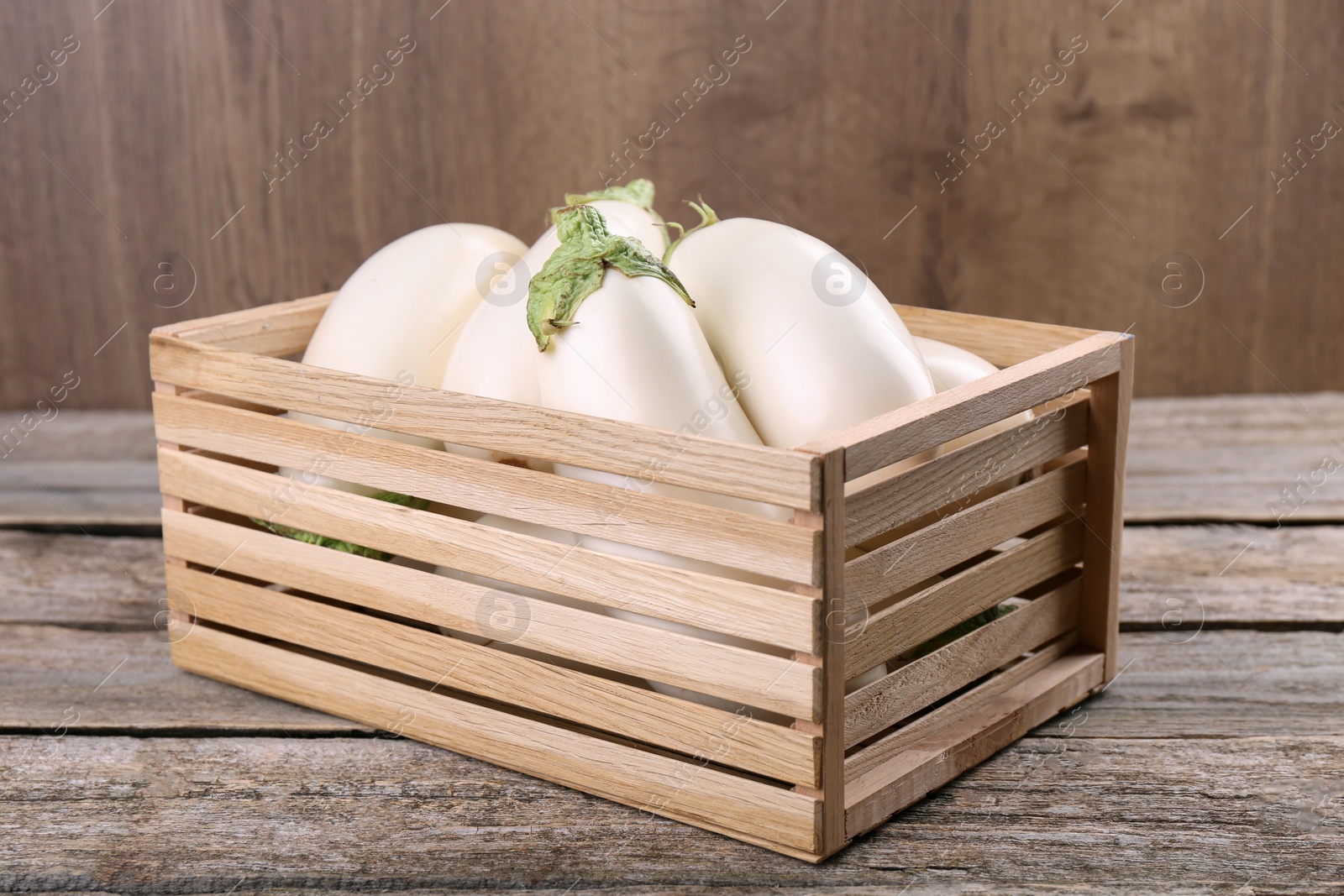 Photo of Fresh white eggplants in crate on wooden table