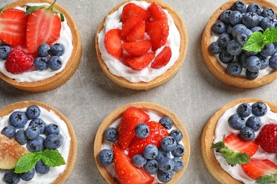 Photo of Delicious sweet pastries with berries on grey table, flat lay