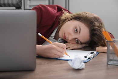 Photo of Sad businesswoman working at wooden table in office