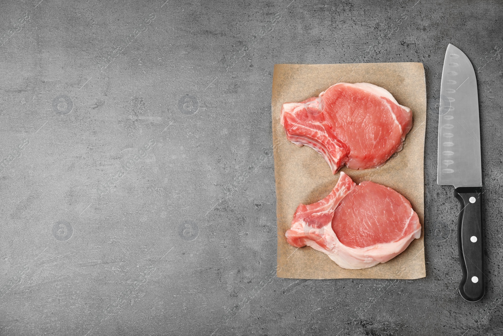 Photo of Flat lay composition with raw meat, knife and space for text on grey background