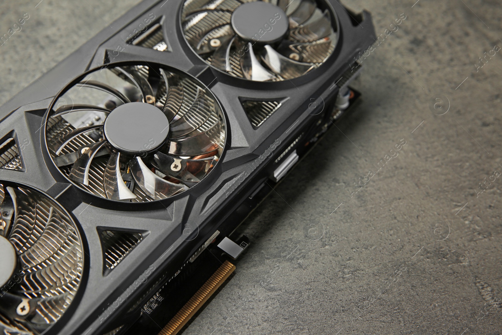 Photo of One computer graphics card on grey textured table, closeup. Space for text