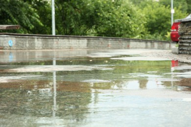 Puddles on city street, closeup. Rainy weather