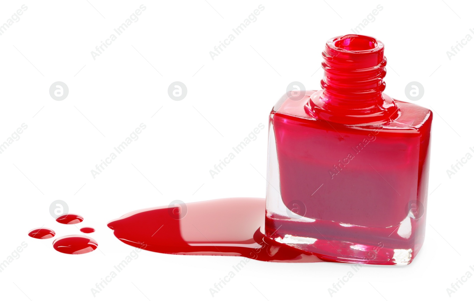 Photo of Bottle and spilled red nail polish isolated on white