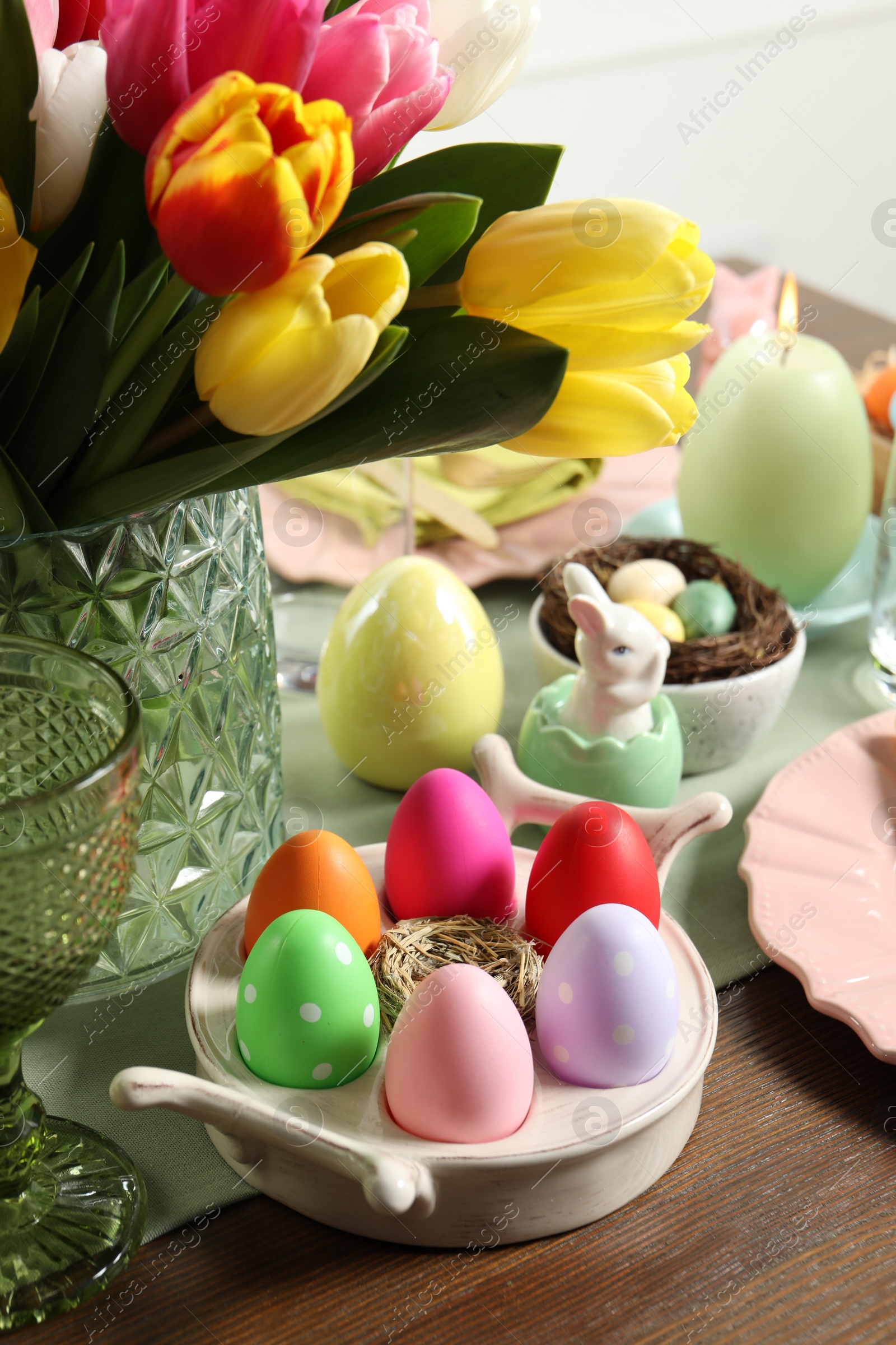 Photo of Easter celebration. Festive table setting with beautiful flowers and painted eggs