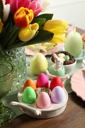 Photo of Easter celebration. Festive table setting with beautiful flowers and painted eggs