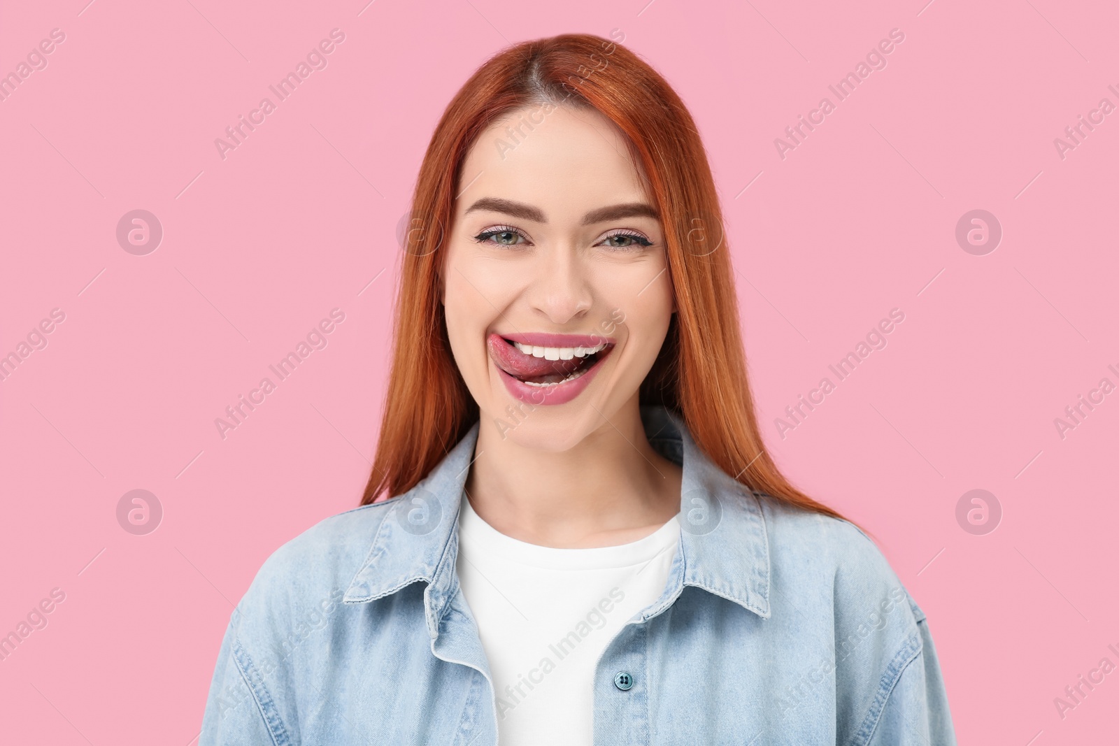 Photo of Happy woman showing her tongue on pink background