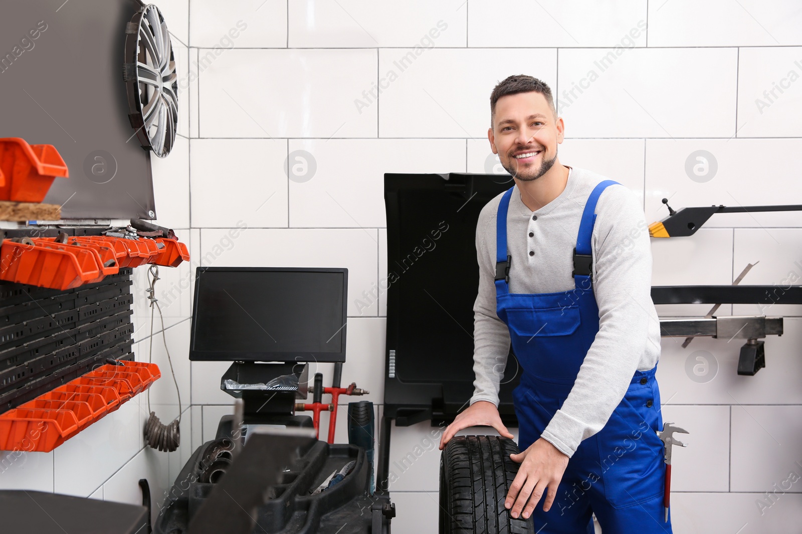 Photo of Mechanic working with wheel balancing machine at tire service