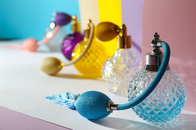 Composition with different bottles of perfume on color background, closeup