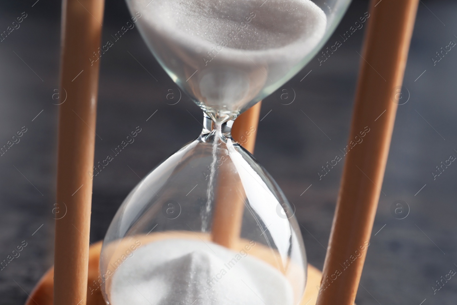 Photo of Hourglass with flowing sand on table, closeup. Time management