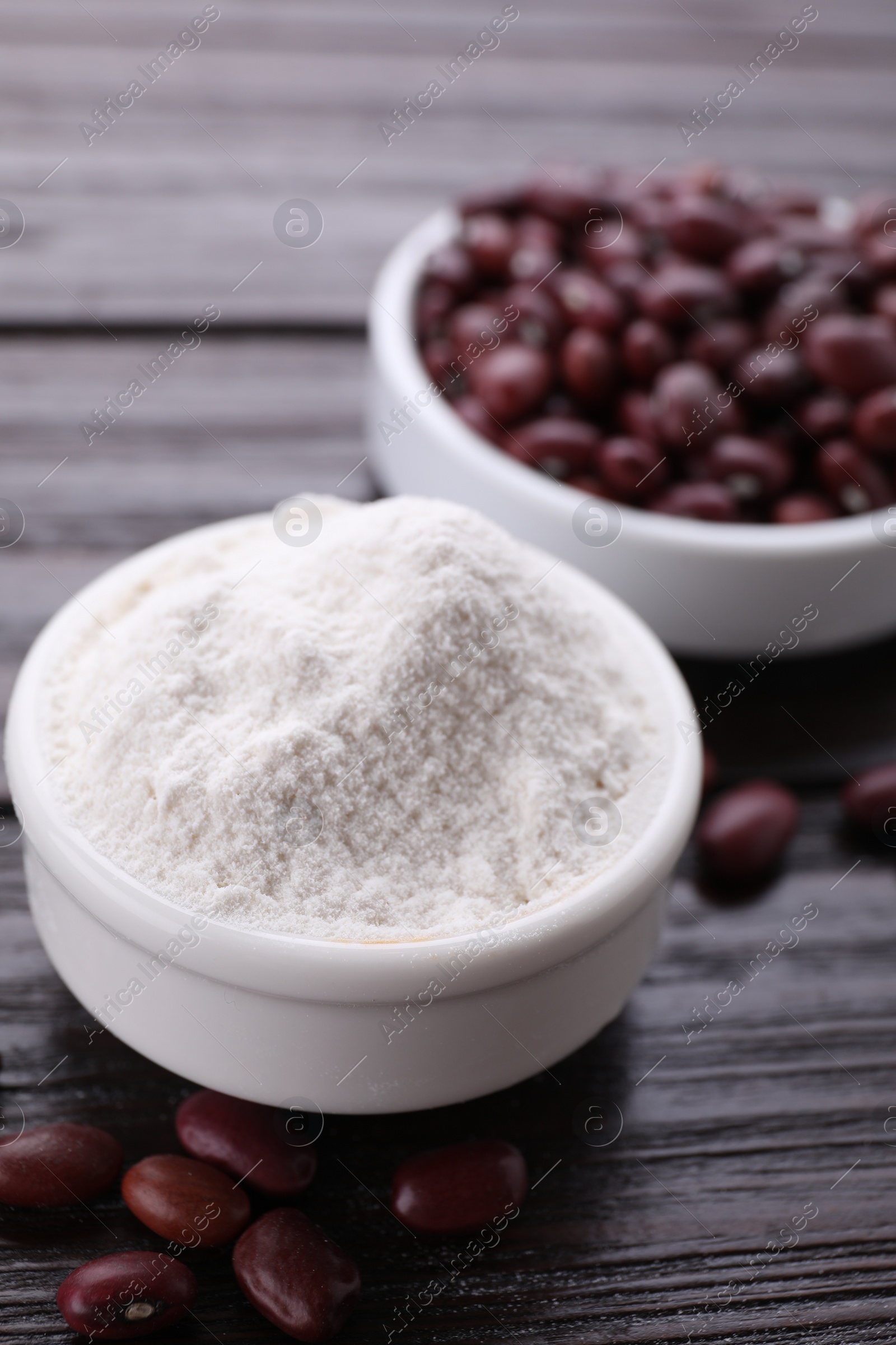 Photo of Kidney bean flour and seeds on wooden table, closeup